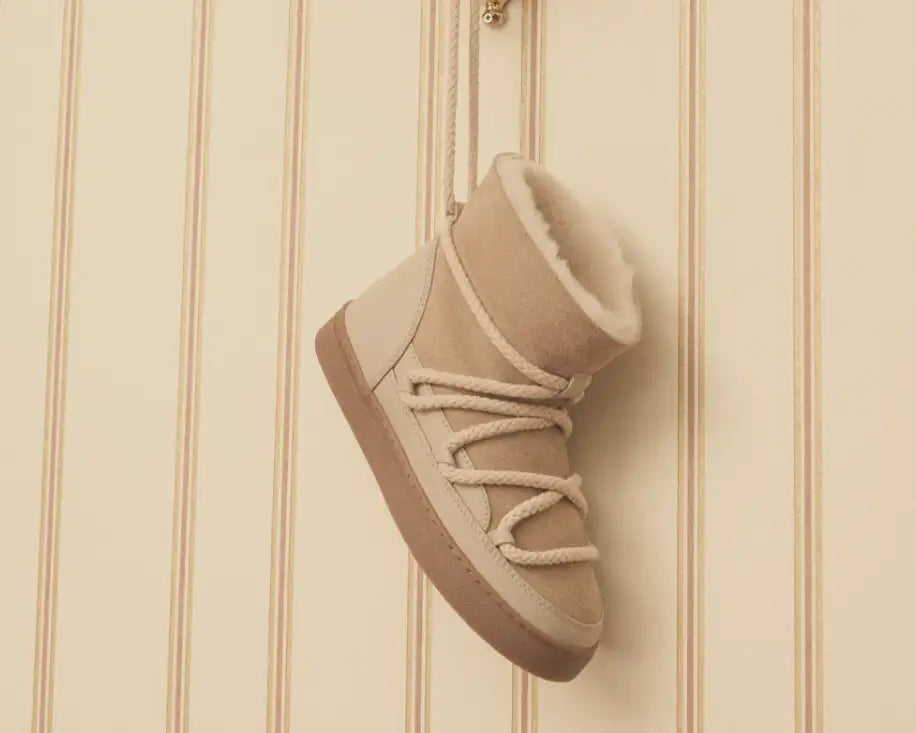 Beige semsket ankelstøvel med kremfargede tau-snøres og en plush shearling-foring.