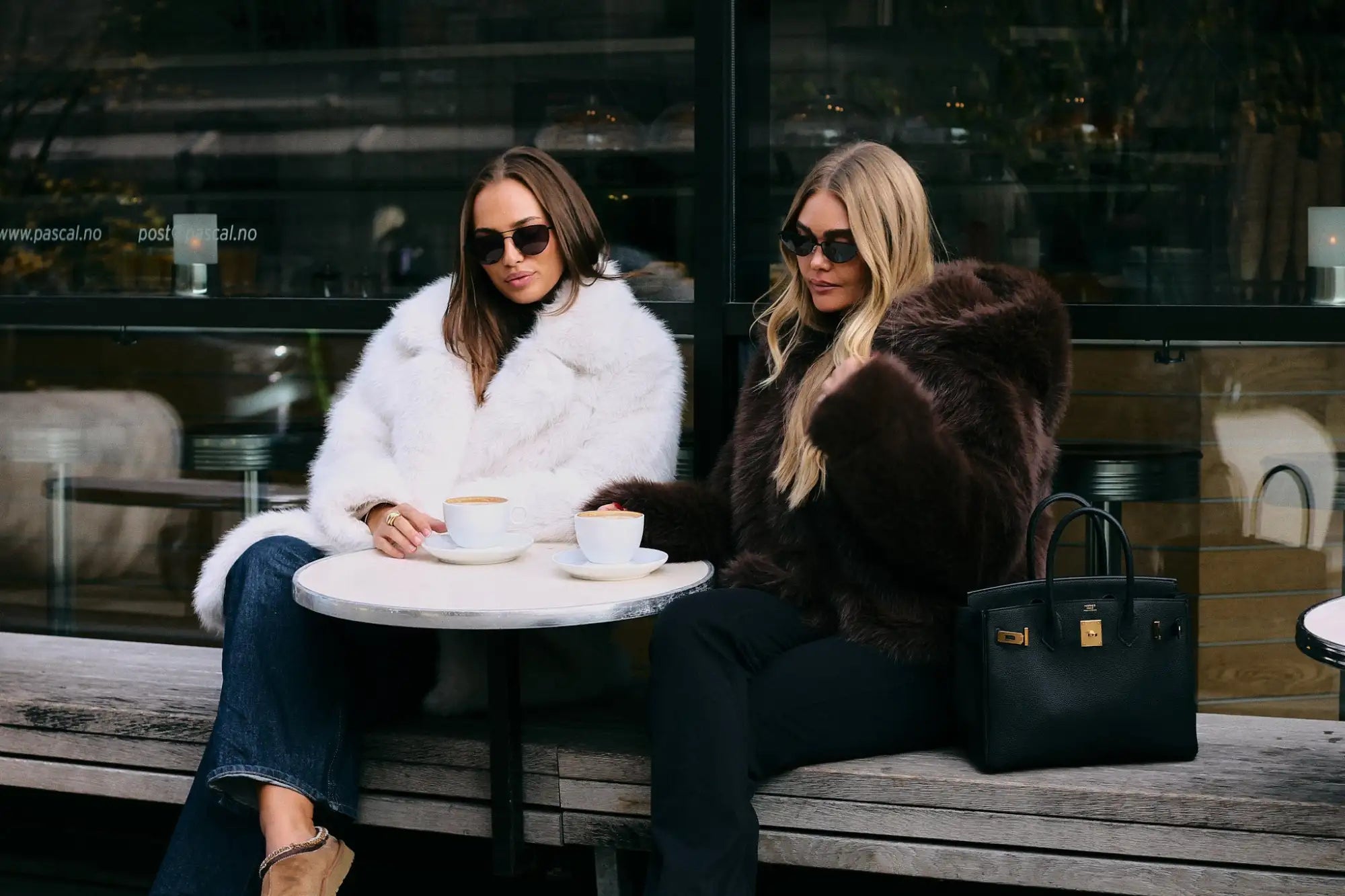 Hvit pelsjakke med svart kant og knapper, klassisk design.